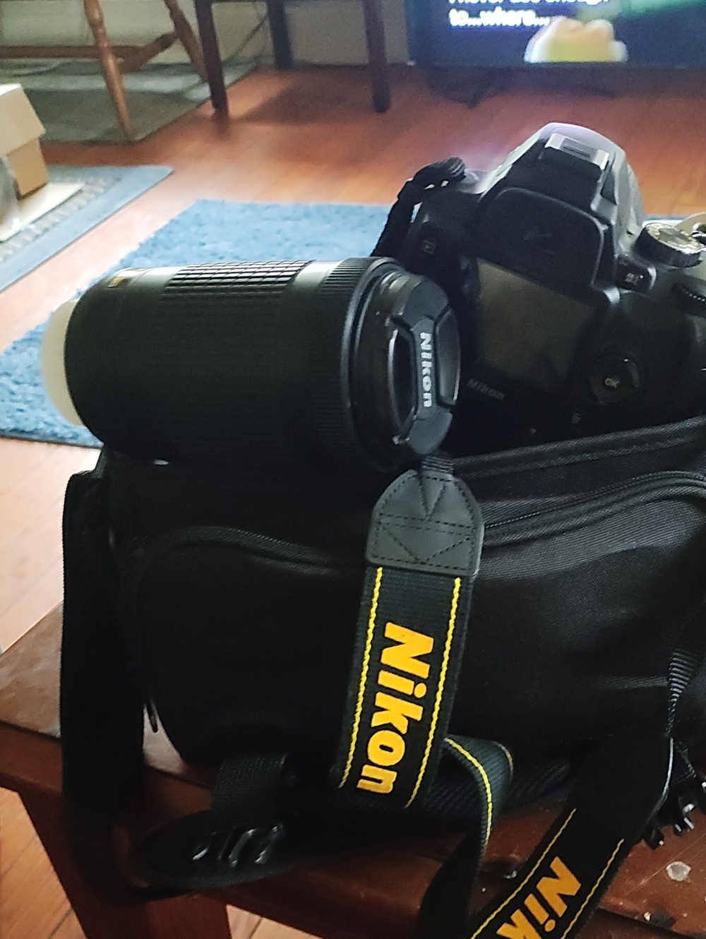 Nikon Black DSLR with Telephoto Lens and Branded Strap
